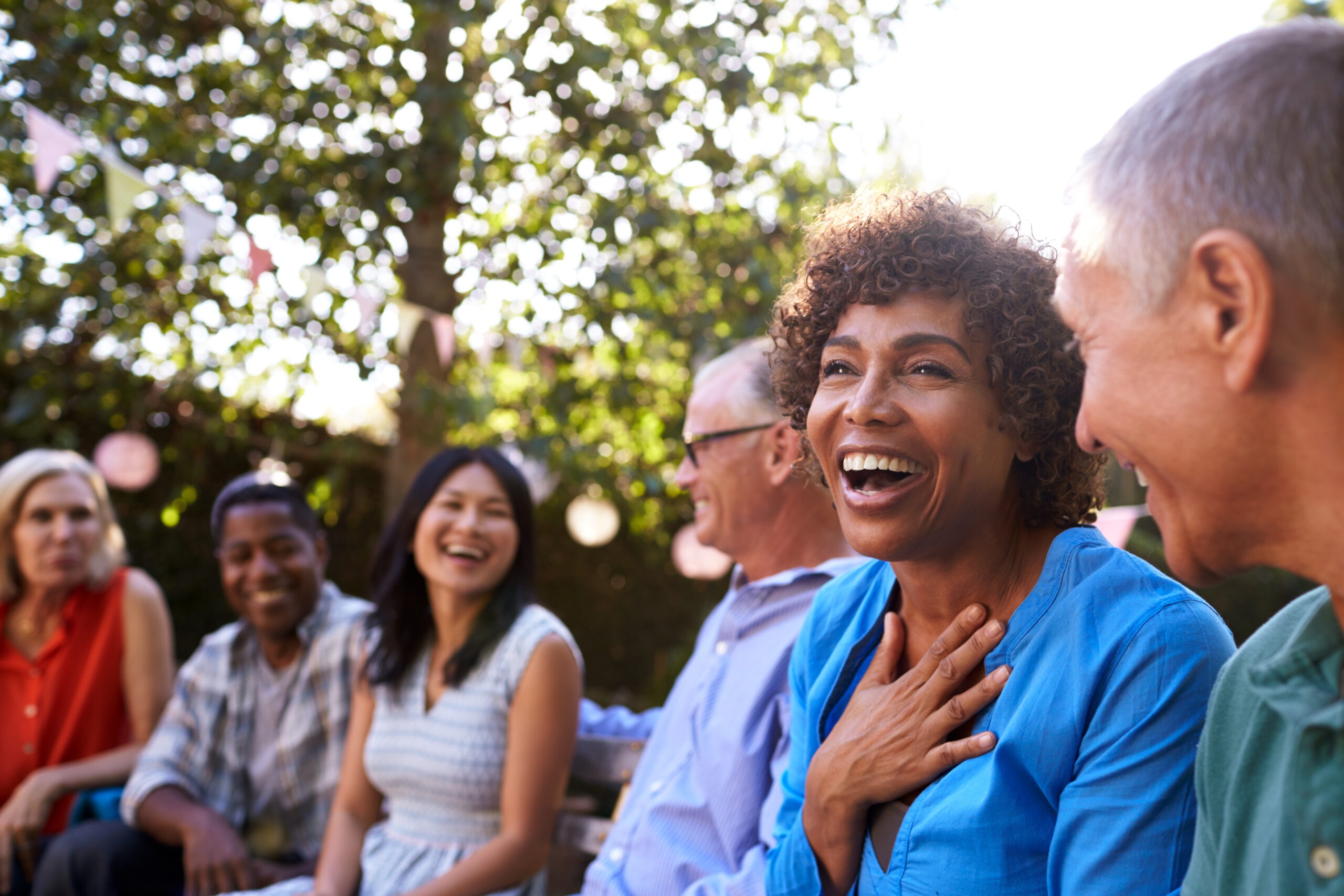 Group Of Mature Friends Socializing In Backyard Together;